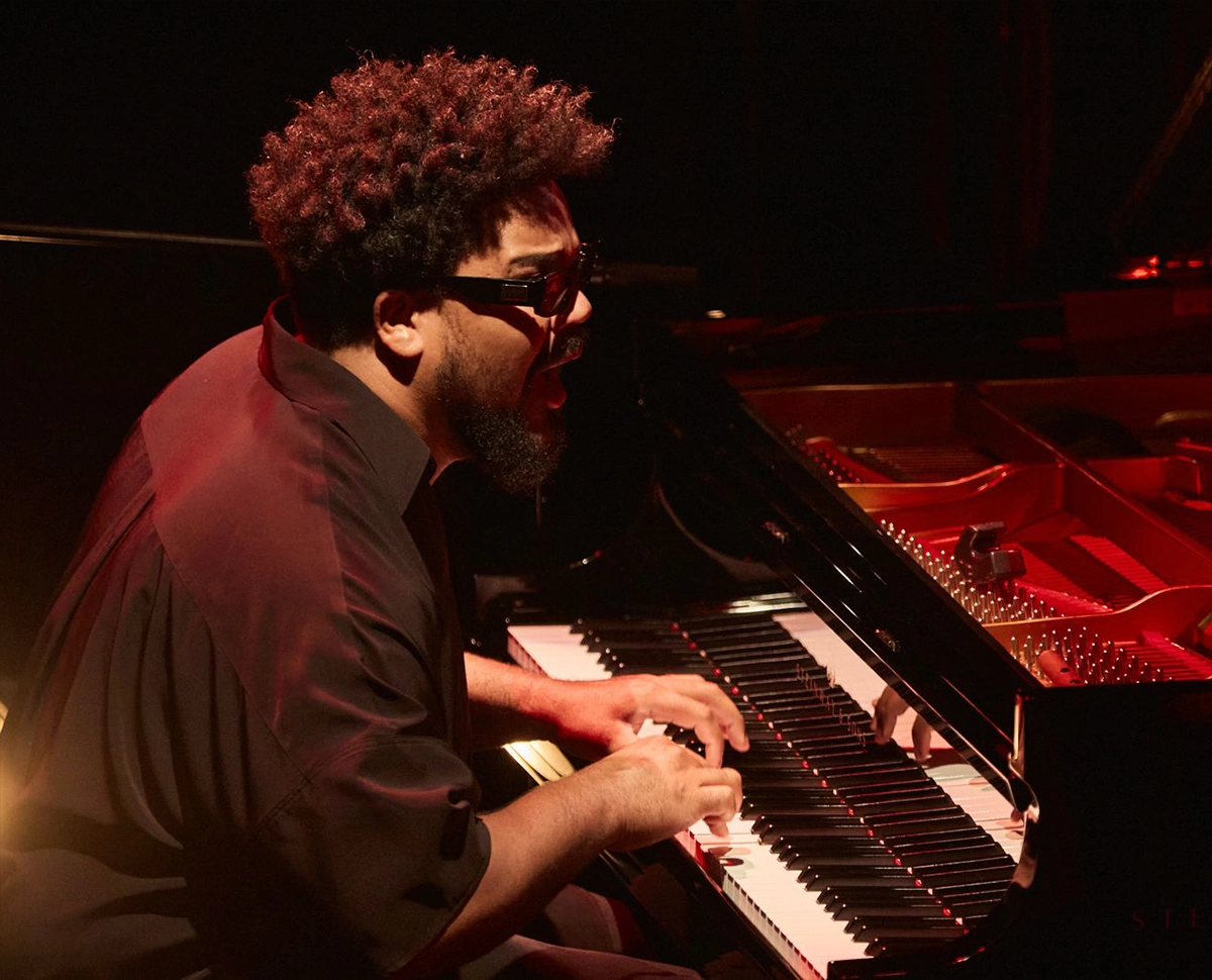 Detalhe em close up de um trompetista performando seu solo